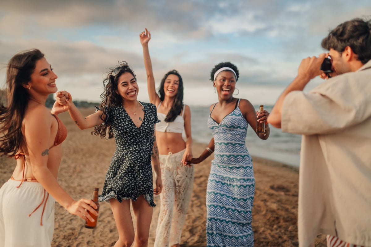Amigos celebrando y disfrutando en la playa durante el atardecer